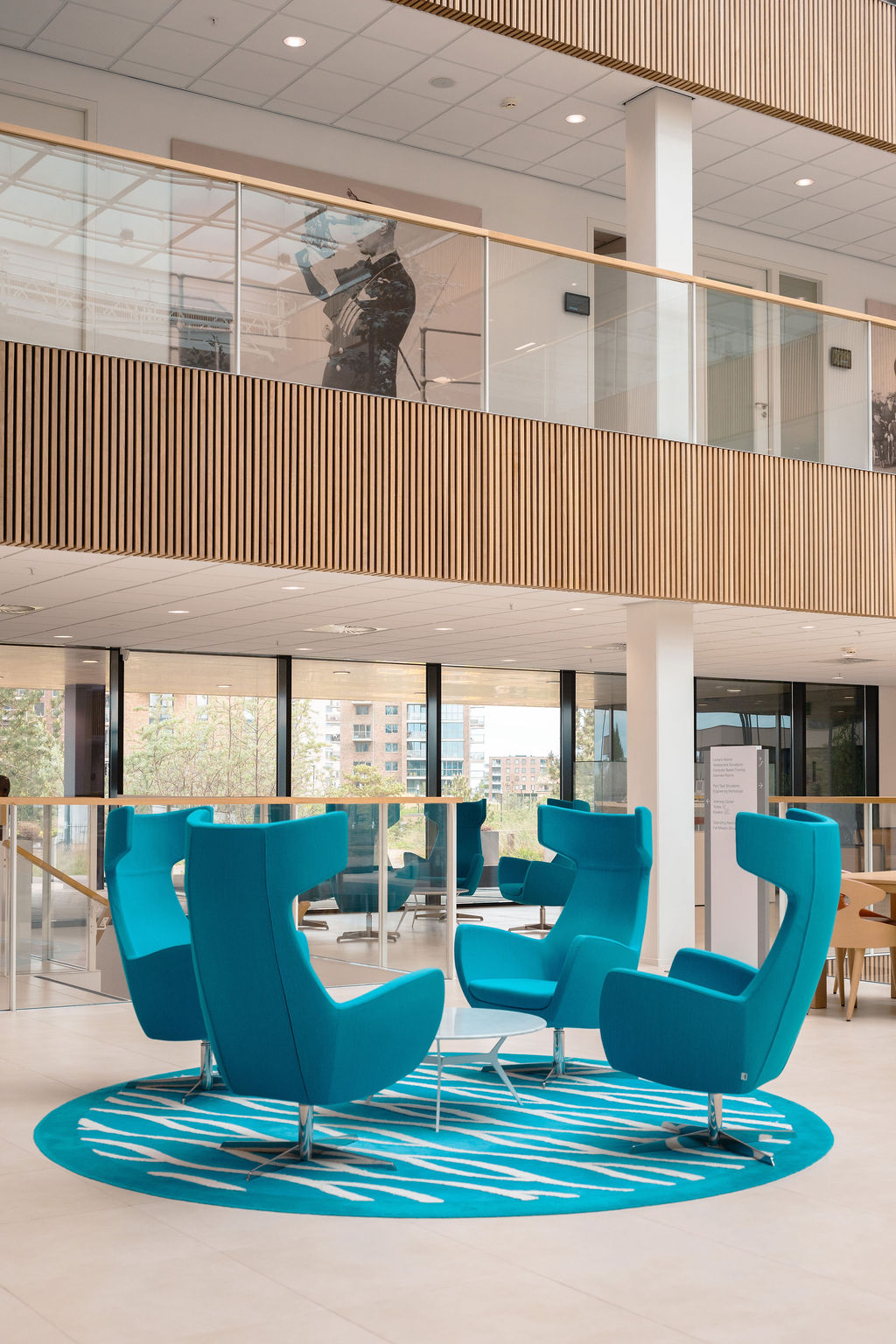 Teal lounge chairs in the light-filled atrium of the CSMART building