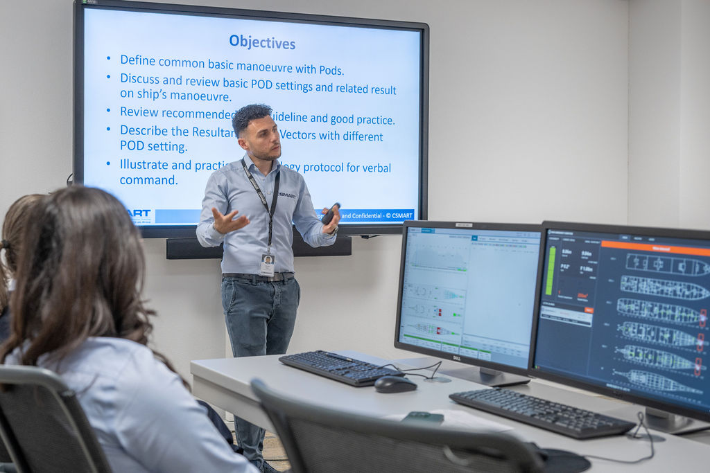 Instructor presents POD manoeuvring objectives in a simulator classroom